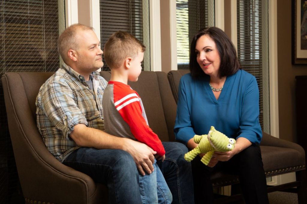 Personal Injury Attorney, Cyndi Crocker, talks with a male client and his son after a car accident