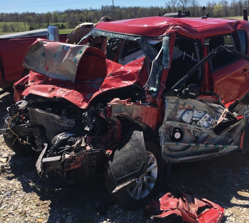 Beth Waddell's wrecked red Kia Soul car at a scrap yard with the front end smashed