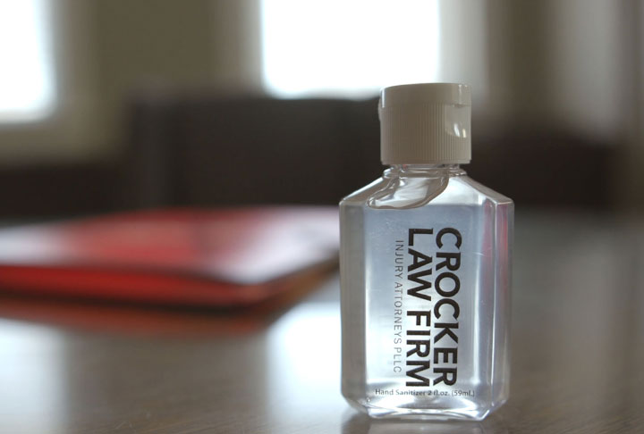 Crocker Law Firm Personal Injury Lawyers hand sanitizer branded bottle sitting on a desk in a conference room