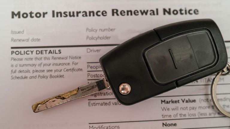 Motor Insurance Renewal Notice document with a car key laying on it