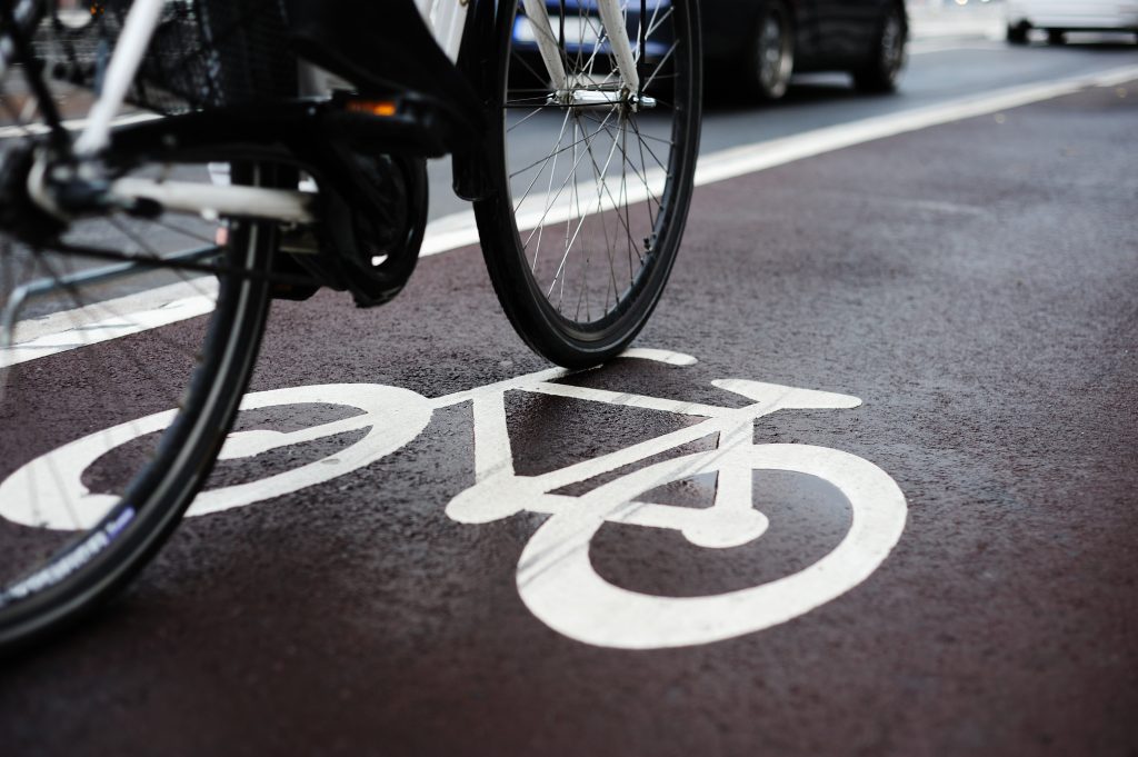 Person riding a bike in a bike lane. Biking laws in Kentucky require drivers to use bike paths if available.