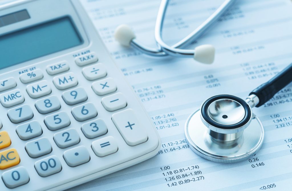 Image of a calculator sitting atop medical bills, which are an important consideration in workers' compensation cases.